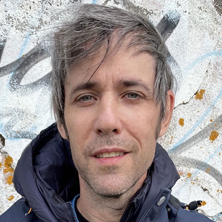 Andrew Deutsch in front of a graffitied wall in Brooklyn